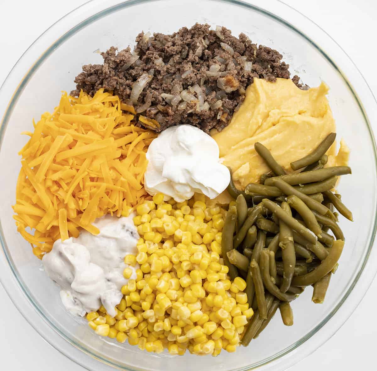 Tater Tot Hotdish is a quick and easy comfort food staple recipe all over the Midwest! This hotdish is full of meat, veggies, soup, cheese, and topped with tater tots for a super satisfying meal! Tater Tot Hotdish, Tater Tot Casserole, How to Make Hotdish, Casserole, Tater Tot Recipes, Dinner, Supper, Recipes, Dinner Ideas, Midwest Recipes, i am baker, iambaker Raw Ingredients for tater tot hotdish in a glass bowl